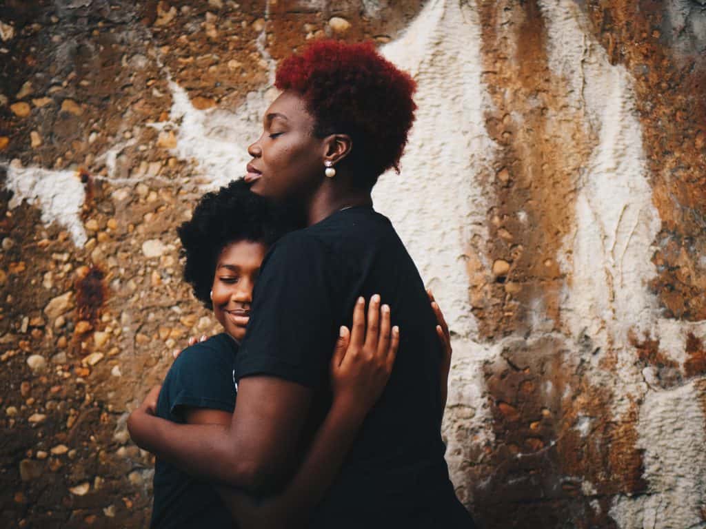 Mother hugging her daughter.