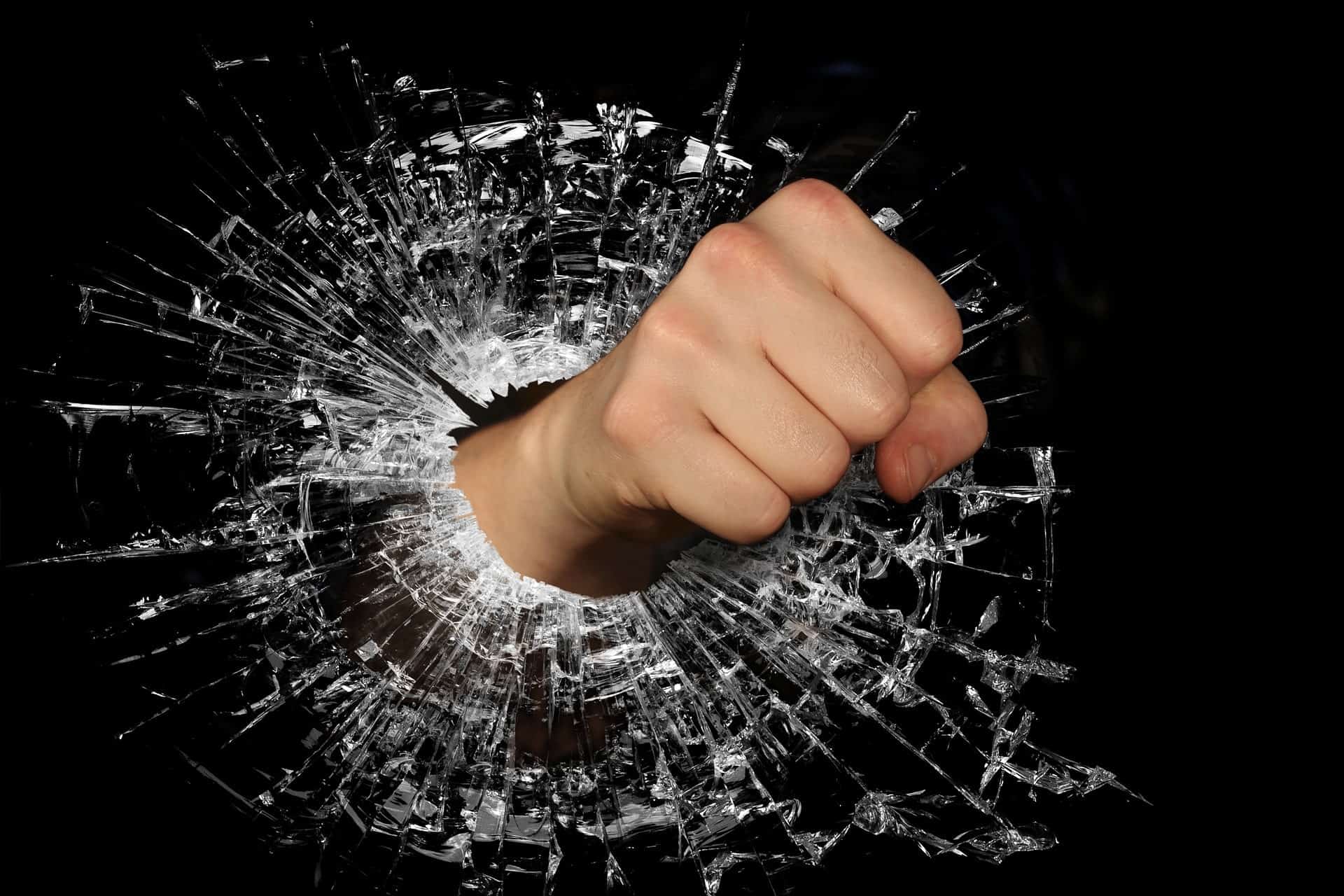 Angry person punching through glass.