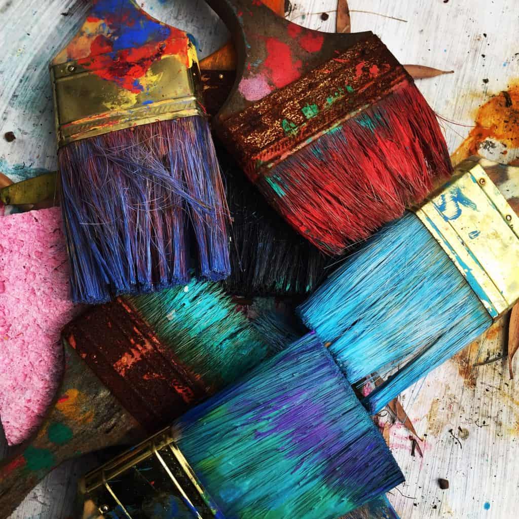 Paint brushes covered in paint.