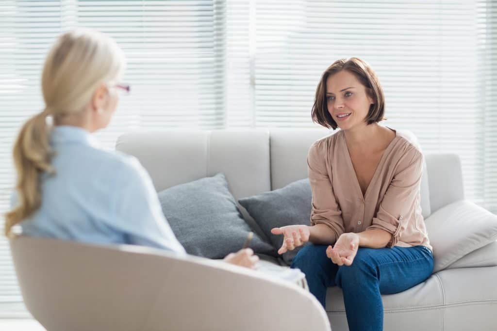 Woman speaking with a therapist about childhood trauma.