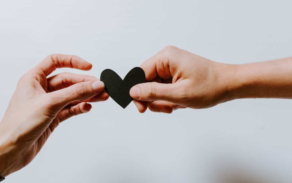 Couple holding a paper heart.