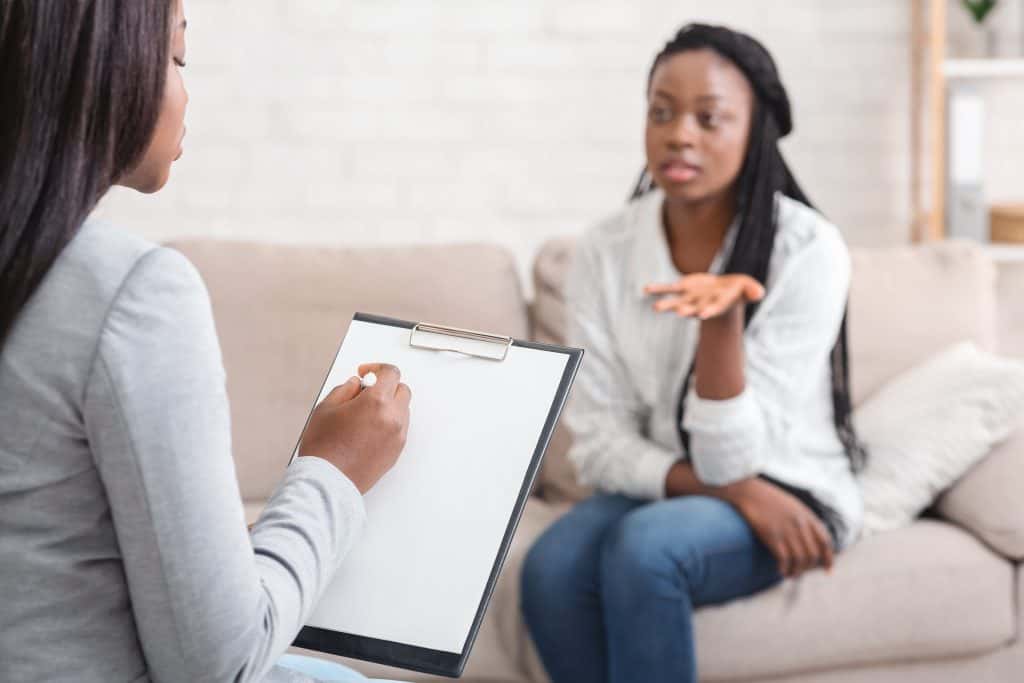 Woman speaking with a black psychologist.