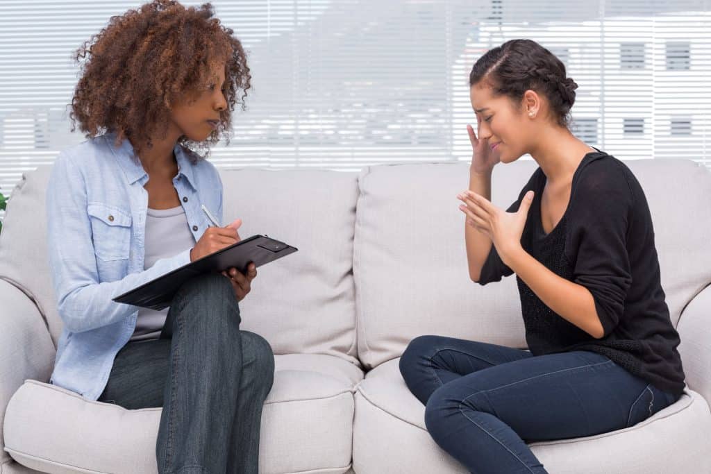 Woman speaking with a black therapist.