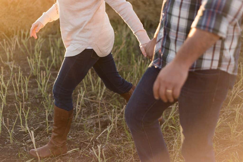 Christian couple walking in a field.